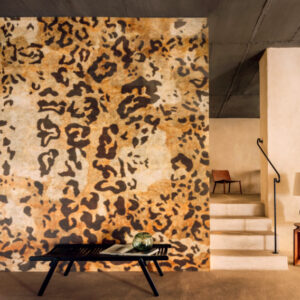 Interieur met Elitis Sauvages VP 969 01 behang met luipaardprint op een grote muur in een stijlvol, modern ingerichte ruimte.