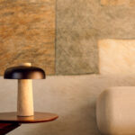 Sfeervolle interieurhoek met Elitis Sauvages VP 971 01 behang, designlamp en beige fauteuil.