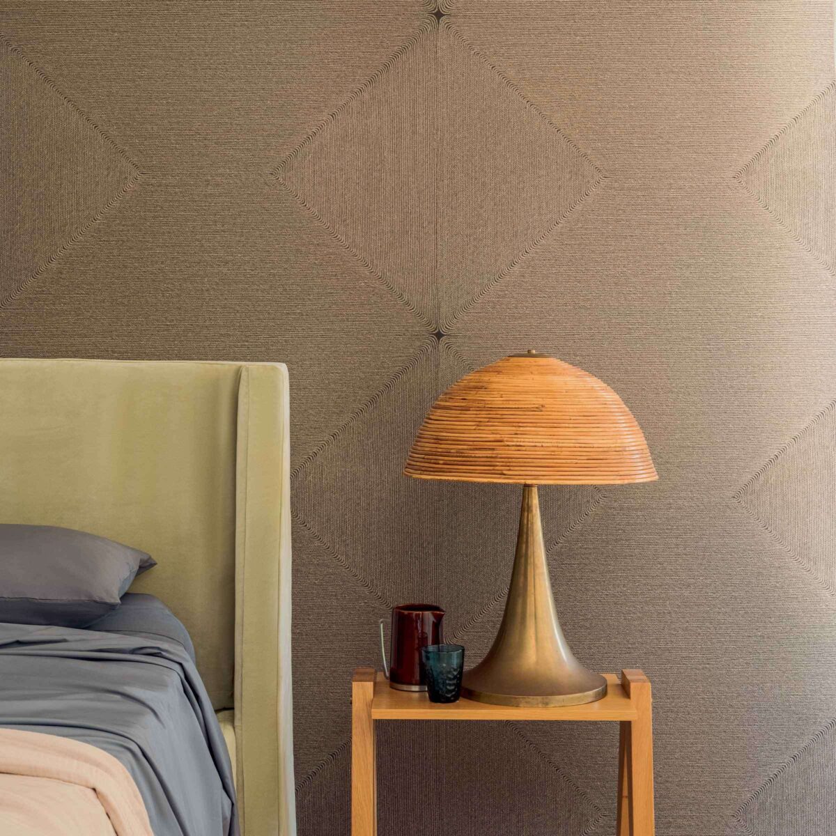 Sfeervolle slaapkamer met Elitis Cordes Sensibles Cocon wandbekleding, fluwelen bed en bijzettafel met retro lamp.