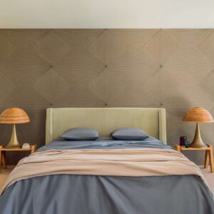Modern ingerichte slaapkamer met een Elitis Cordes Sensibles wandbekleding en een bed met pastelkleuren en houten accenten.