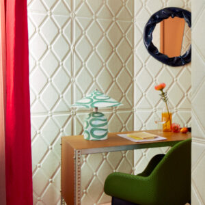 Sfeervolle werkhoek met Elitis Forms Mone Lin RM 1057-01 wandbekleding, een houten bureau, groene designstoel en retro tafellamp.