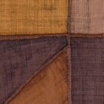 Detailopname van Elitis La Caravane Kungbo VP 944 07 behang met handgeweven textuur in warme aardetinten.