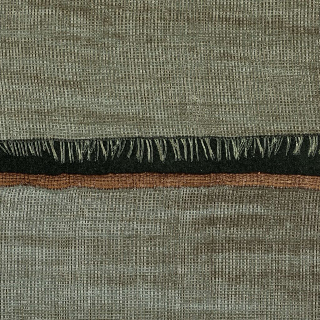 Detailopname van het Elitis La Caravane Moshi Moshi VP 942 07 behang met geweven textuur en decoratieve franjes.