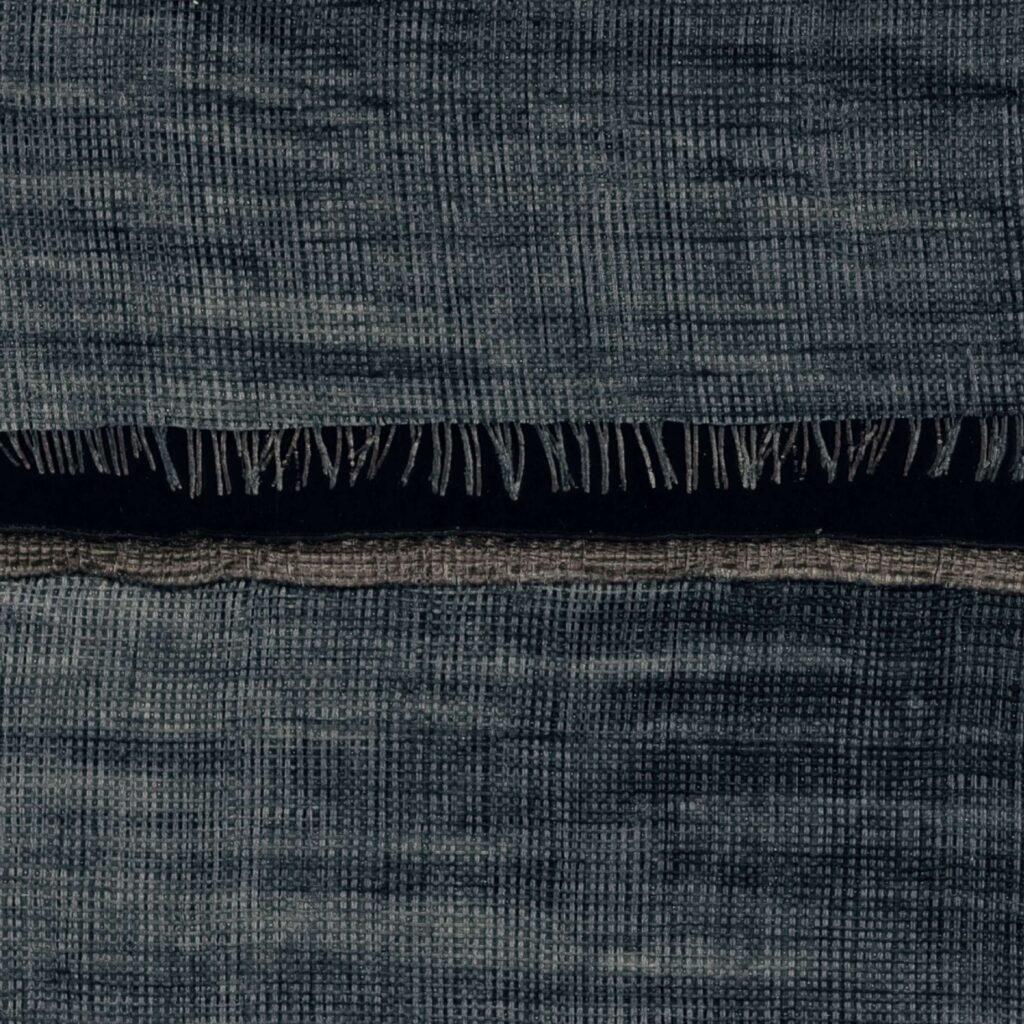 Detail van een donkerblauw textiel met een geruit weefpatroon en franjes, uit de Elitis La Caravane Moshi Moshi VP 942 12 collectie.