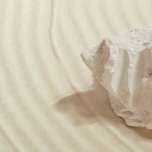Grote witte steen op beige Elitis Le Jardin d’Aloès Palimpseste linnen stof met subtiel golvend reliëf.