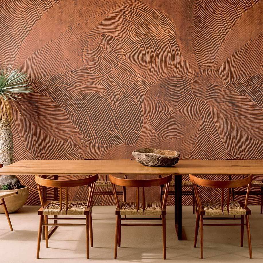 Houten eetkamer met Elitis Mural 'Bois Sculpté Nuit Cinétique' wandbekleding met organisch reliëfpatroon.