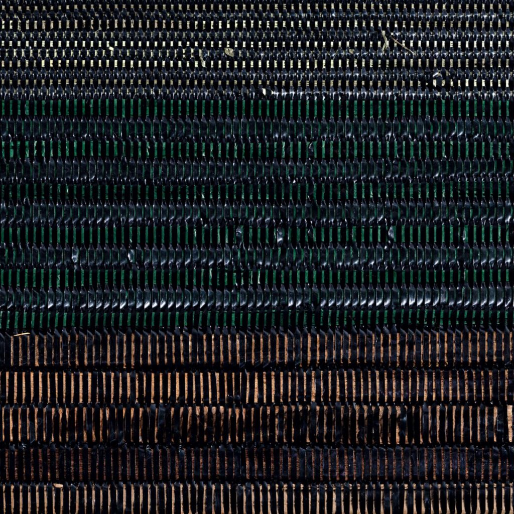 Detail van de Elitis S.O.L.O. Wall Silver RM 1007-80 wandbekleding met geweven metallic en textiele structuren in zilver, groen en bruin.