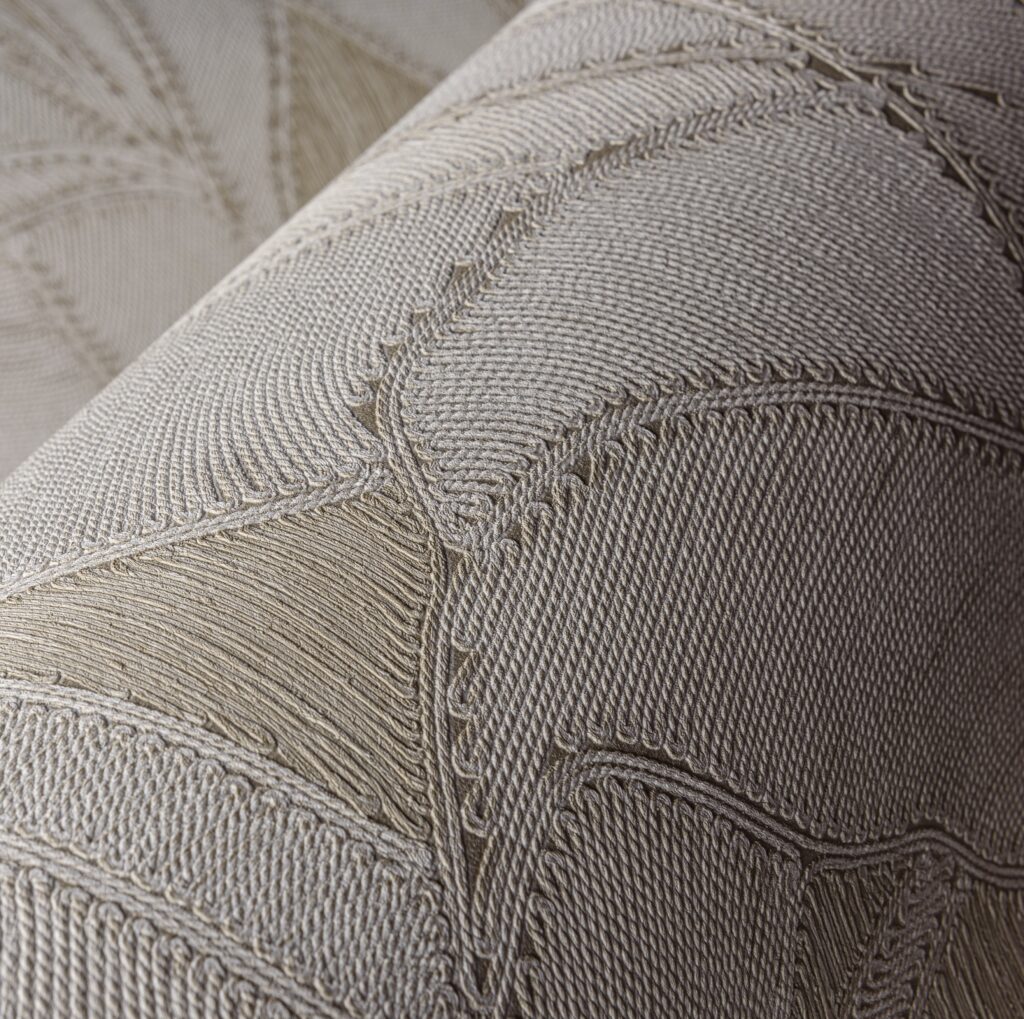 Detailopname van het textiele reliëfpatroon van de Arte Manila Botanic 64503 wandbekleding in aardetinten.