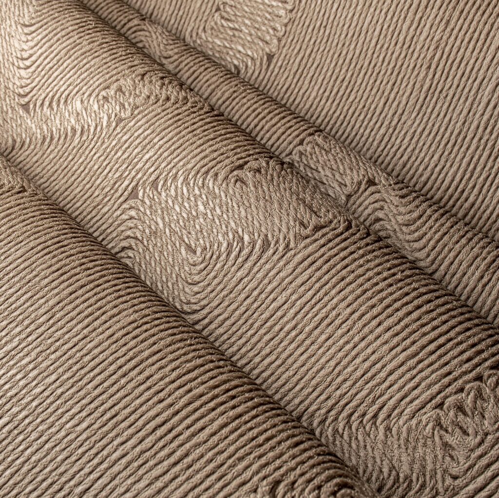 Detailopname van de Arte Manila Edge 64520 wandbekleding met een reliëfstructuur van horizontale, golvende lijnen.