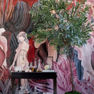 Een kleurrijk interieur met een groene plant, glazen karaffen op een zwarte tafel en een wandbekleding met abstracte figuren uit de Arte collectie _97720_.