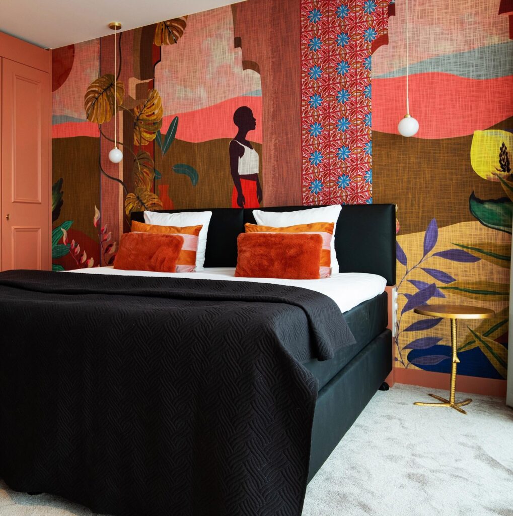 Sfeervol ingerichte slaapkamer met een opvallend Arte Sfeer 97530 wandpaneel vol kleurrijke patronen en kunstzinnige illustraties.
