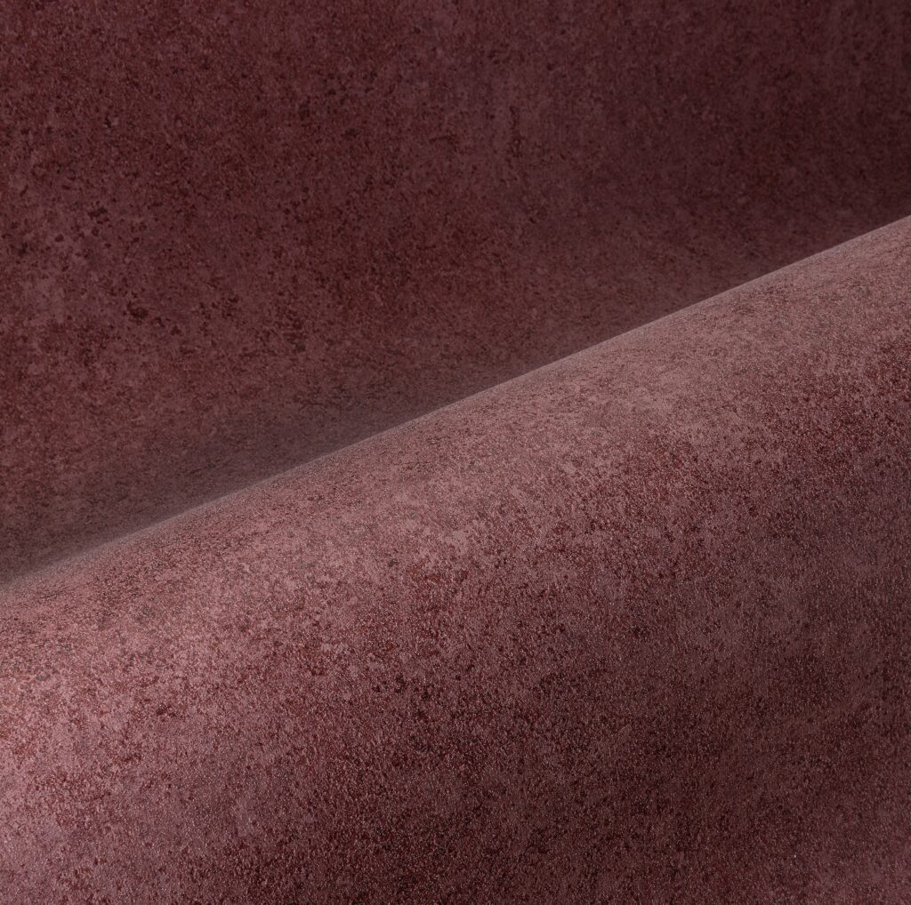 Detailopname van de roodbruine Arte Essentials Kaolin Calcaire Stucco wandbekleding met een licht ruwe textuur.