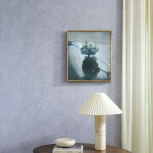 Sfeervolle ruimte met Arte Essentials Kaolin Calcaire Stucco muur, een schilderij, een designlamp en een ronde tafel.