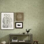 Interieur met metalen consoletafel, kunst aan de muur en groene Arte Essentials Kaolin Fragment 30337-behang met subtiel bladmotiëf.