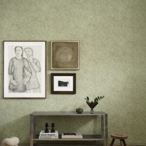 Interieur met metalen consoletafel, kunst aan de muur en groene Arte Essentials Kaolin Fragment 30337-behang met subtiel bladmotiëf.