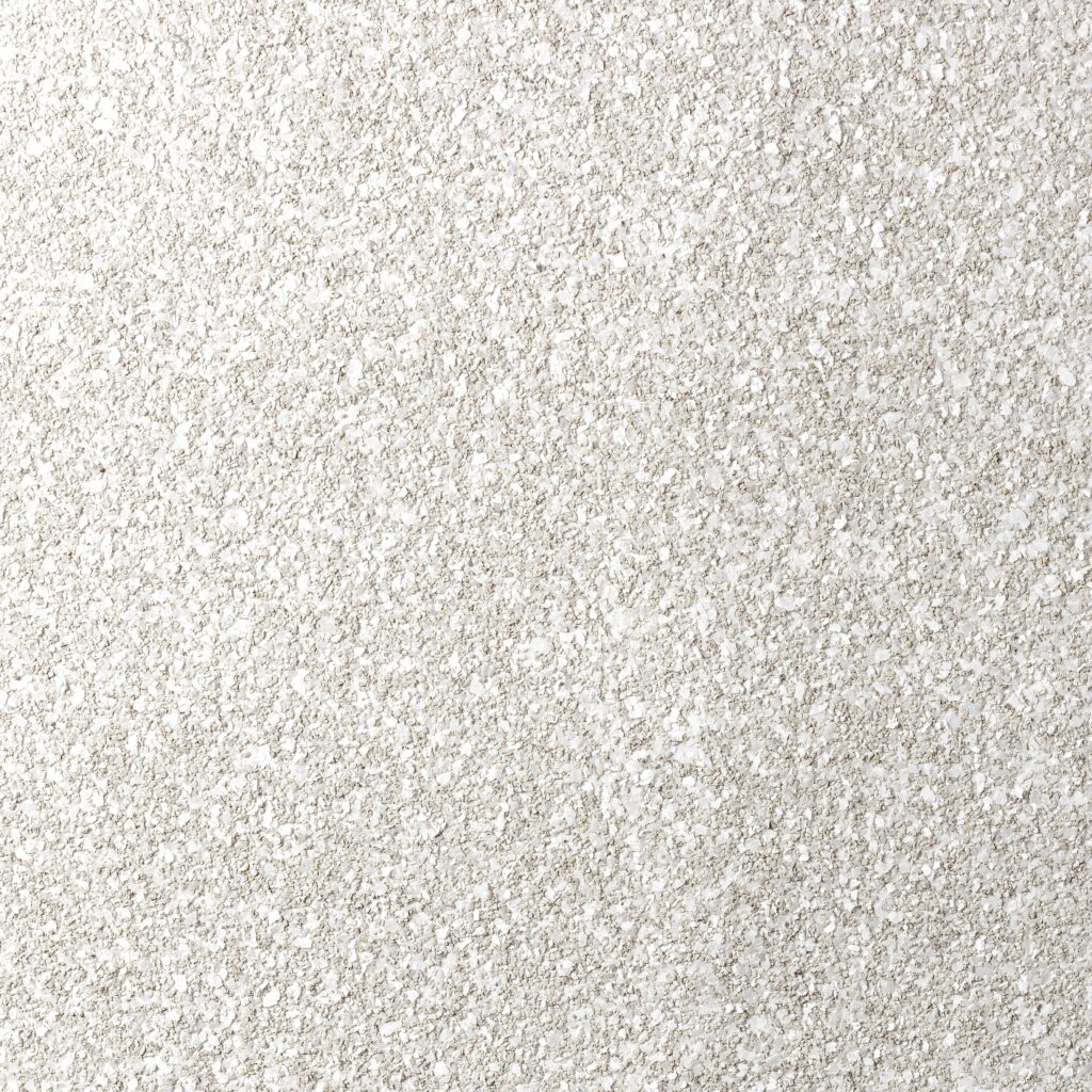 Close-up van de textuur van het Arte Essentials Kaolin Grezzo 30385 behang met een ruwe, korrelige afwerking in lichte, neutrale tinten.