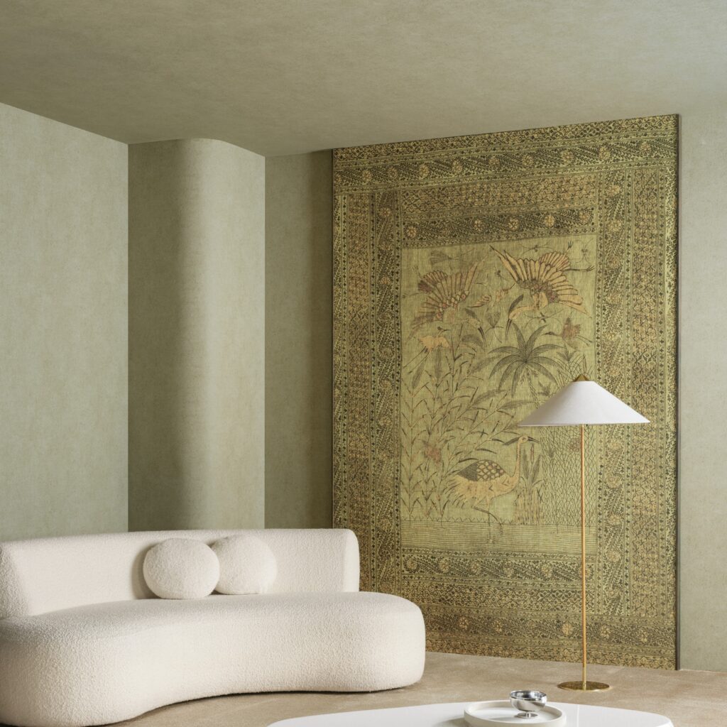 Sfeervol interieur met een lichtgroene wand bekleed met Arte Essentials Kaolin Passeggio 30370 behang, een crèmekleurige designbank en een stijlvolle vloerlamp.