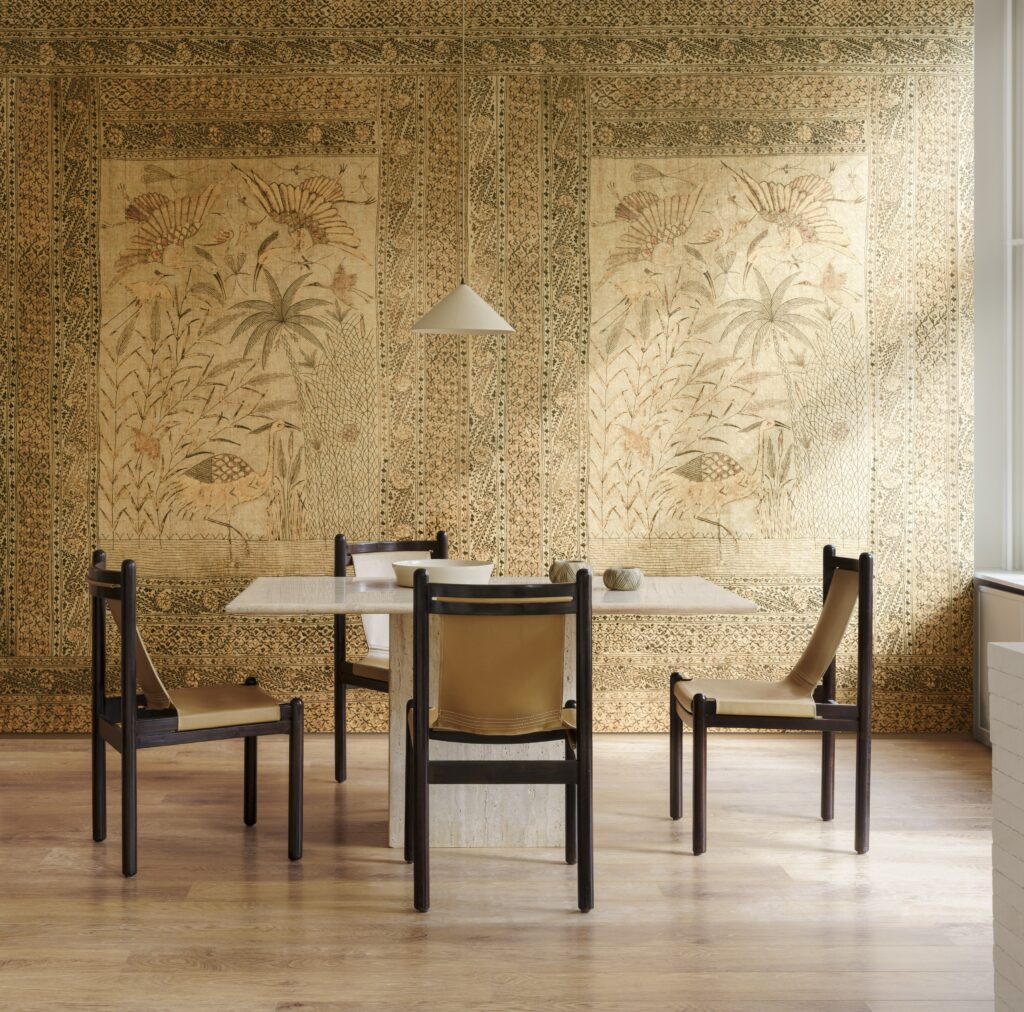Moderne eethoek met travertin tafel en leren stoelen tegen een sierlijk wandpaneel uit de Arte Essentials Kaolin Passeggio collectie.