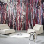 Moderne zithoek met witte fauteuils, een glanzend krukje en kleurrijk Arte Mangrove 97741 behang met abstracte boomtakken.