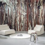 Modern ingerichte zithoek met twee witte loungefauteuils, een rond vloerkleed en een opvallend Arte Mangrove wandpaneel met boomachtige patronen op de achtergrond.