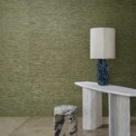 Interieur met groene Arte Prismatic Gradient 52405 wandbekleding, een marmeren bijzettafel, gekleurde kruk en een opvallende lamp.