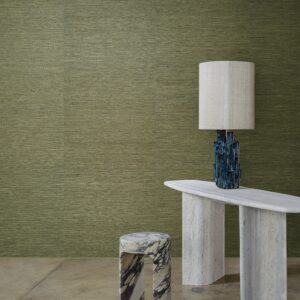 Interieur met groene Arte Prismatic Gradient 52405 wandbekleding, een marmeren bijzettafel, gekleurde kruk en een opvallende lamp.