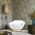 Moderne zithoek met witte designstoel, geometrisch Arte Prismatic Refraction 52460-behang en sfeervolle verlichting.