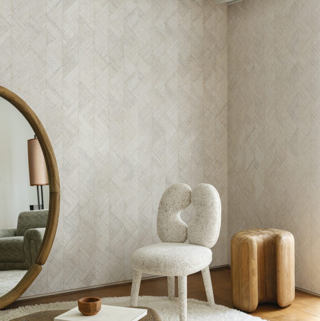 Interieur met Arte Prismatic Rutile 52422 behang, een designstoel, houten krukje en ronde spiegel in een moderne woonruimte.
