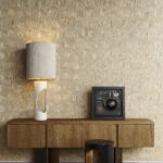 Houten console met tafellamp en kunstobject tegen een beige geometrisch Arte Reflect 52481 behang.