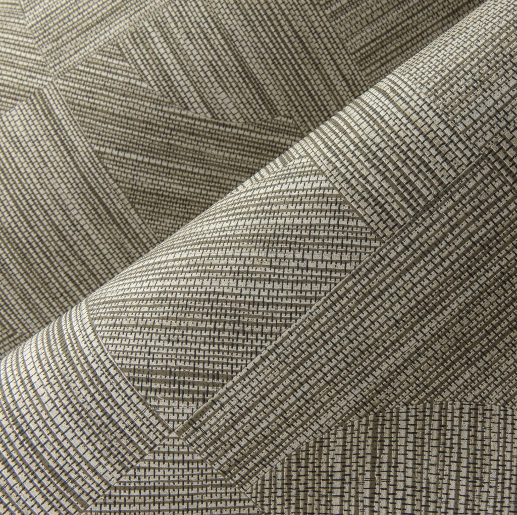 Detailopname van het geweven textuurpatroon van de Arte Splice 24085 wandbekleding in beige en grijstinten.