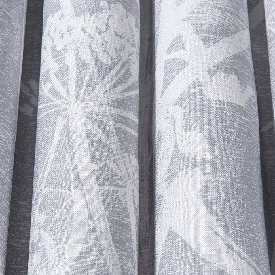 Gordijnstof met een wit silhouetpatroon van fluitenkruid en vogels op een grijze achtergrond uit de Cole and Son Cow Parsley collectie.