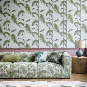 Woonkamer met tropisch ingerichte sfeer, met Cole and Son Palm Jungle behang en bijpassende bank met palmbladmotief.