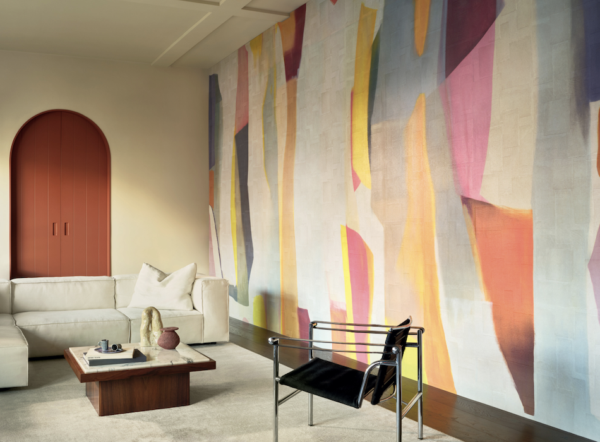 Modern ingerichte woonkamer met Elitis Sangpi panorama behang in kleurrijke abstracte patronen op de muur.