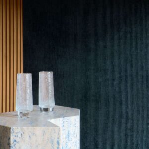 Detail van een bijzondere textielmuurbekleding met een blauw ribbeltje, geplakt op een kast.