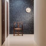 Muur in een hal van Behang met schelpmotief van Elitis Ecume Nyx in parelmoer zwart