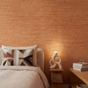 Slaapkamer muur met het oranje Marr Arrowroot behang van Elitis, behang met een grove natuurlijke structuur