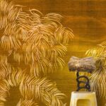 Woonkamer met op de muur Nosara van Elitis: een goudkleurige voorstelling van een landschap