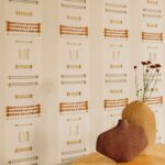 Muur met het behang Elitis Origine Icone van gerecycled katoen met geometrisch patroon in beige