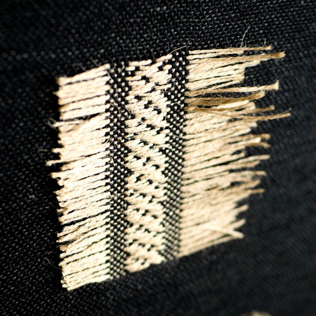 Detail van het behang Elitis Origine Icone van gerecycled katoen met geometrisch patroon in zwart