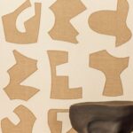 Detail van behang: Elitis Origine Treveni, linnen behang met geborduurde patronen in beige en wit