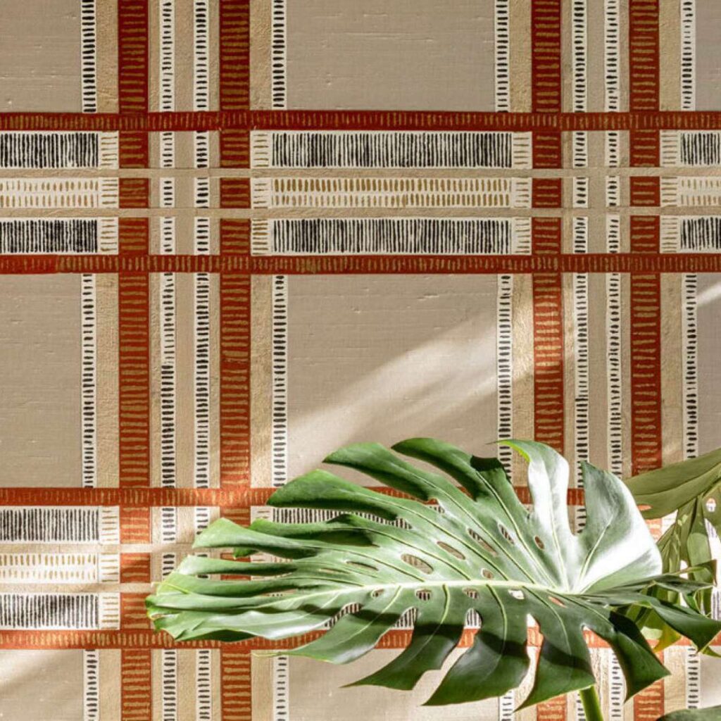 Muur met het zijdebehang Pamir Shariz met een blokpatroon van Elitis in rood, beige en goud