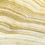 Kleurdetail van Elitis Terres emmêlées panorama behang van een gesteente in goud en groen
