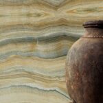 Elitis Terres emmêlées panorama behang van een gesteente in goud en groen