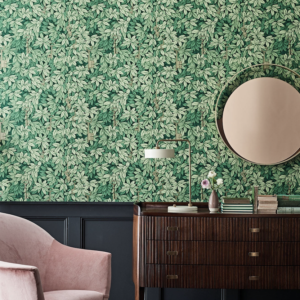 Woonkamer met Fornasetti-behang met groene bladeren, en verborgen gouden sleutels tussen het gebladerte.