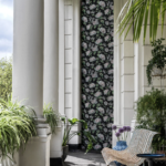 wwonkamer met het Fornasetti-behang Ramo di Ortensia met meerkleurige hortensia bloemen op een zwarte achtergrond