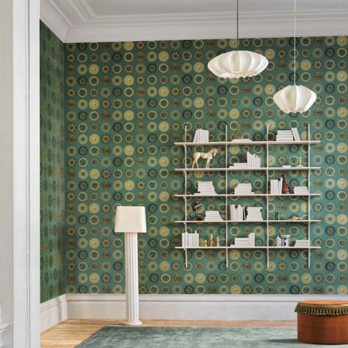 Toepassing van Fornasetti-behang Soli met zonnetjes in groen en goud in een woonkamer