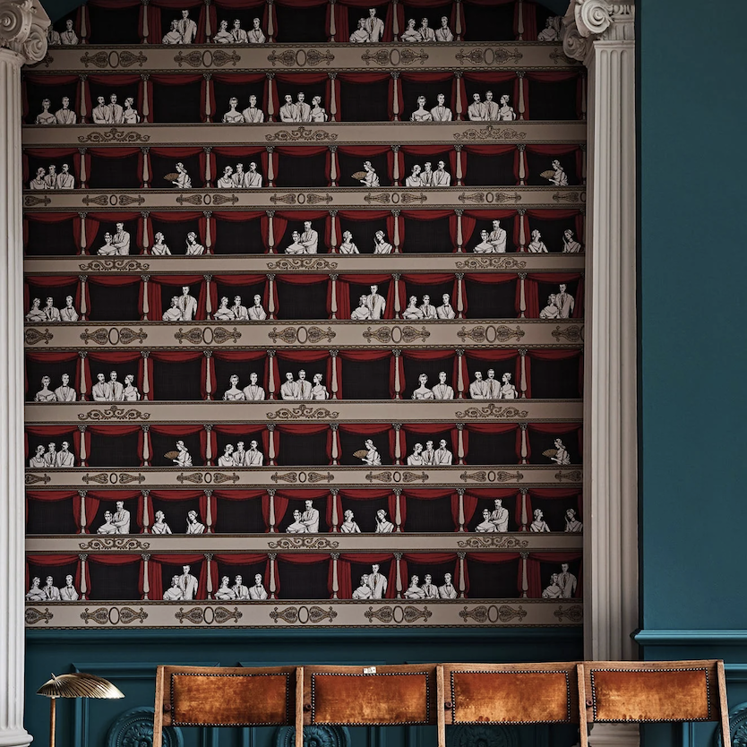 Toepassing op de muur van het Fornasetti-behang Theatro met elegante theaterbezoekers en rode gordijnen.