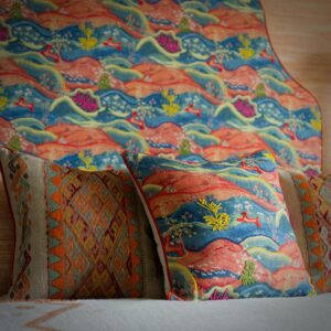 Detail van een geschulpt hoofdbord en kussen van de Andrew Martin stof meadow multi
